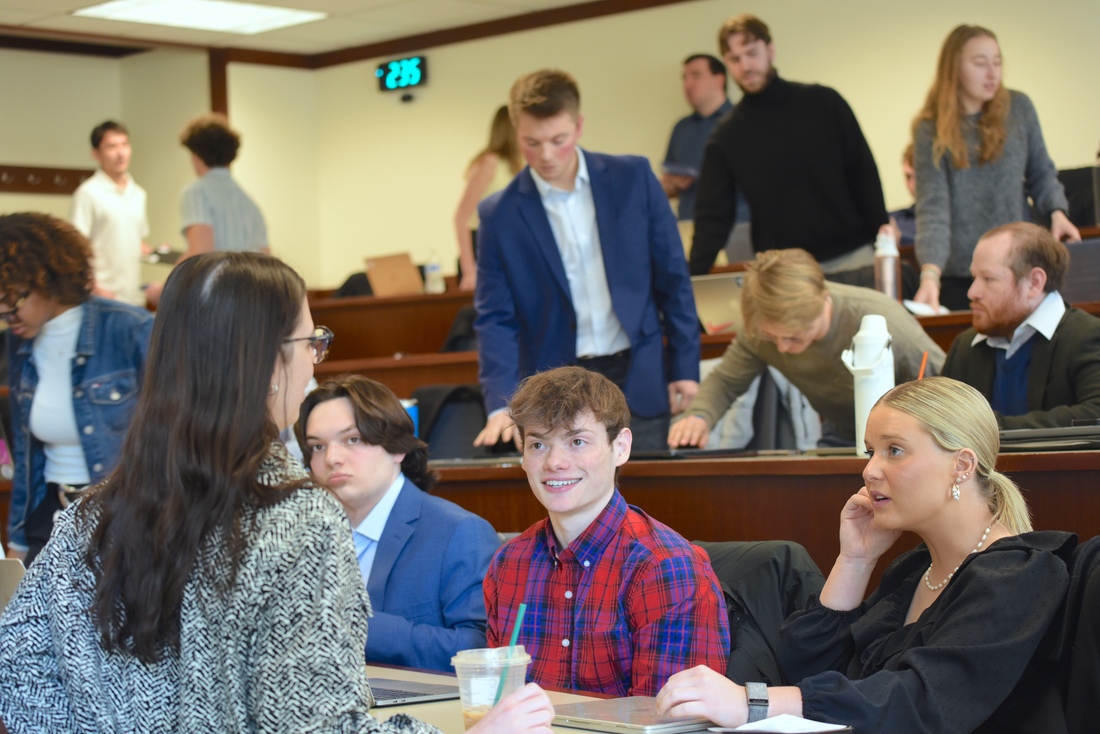 Students chat in a lecture hall as they settle into their seats 