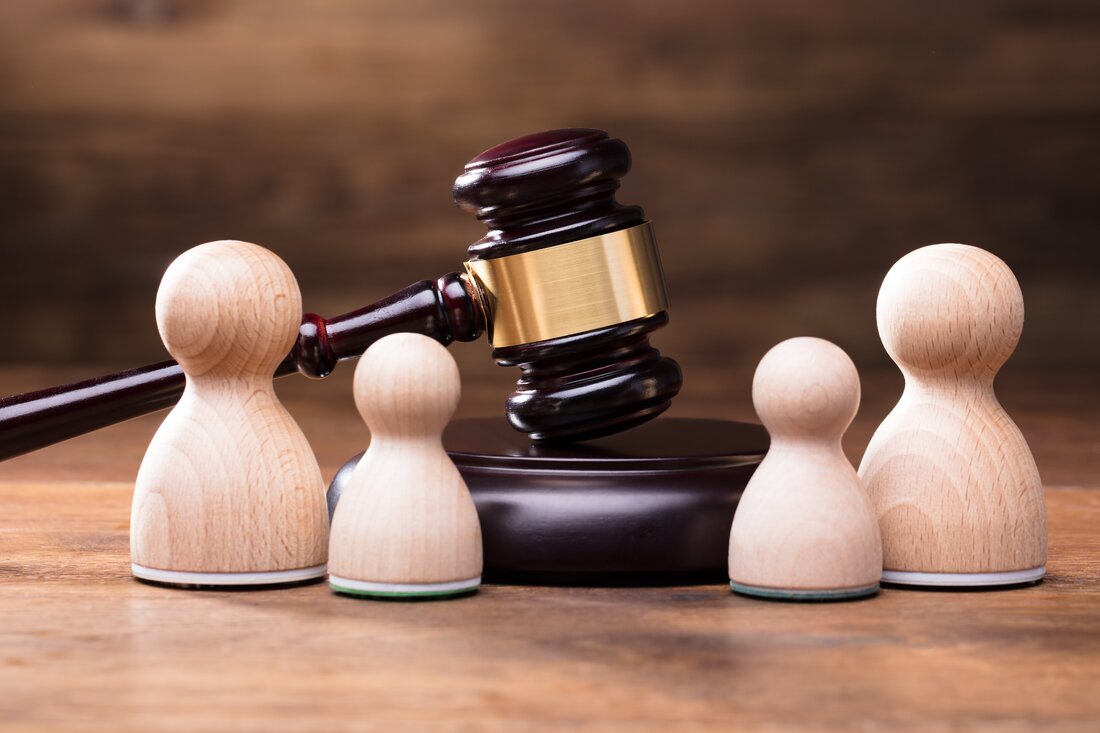 Judge's gavel surrounded by pawns
