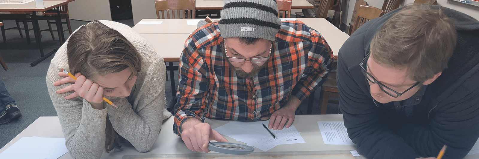 Geography students viewing map in Richardson Library